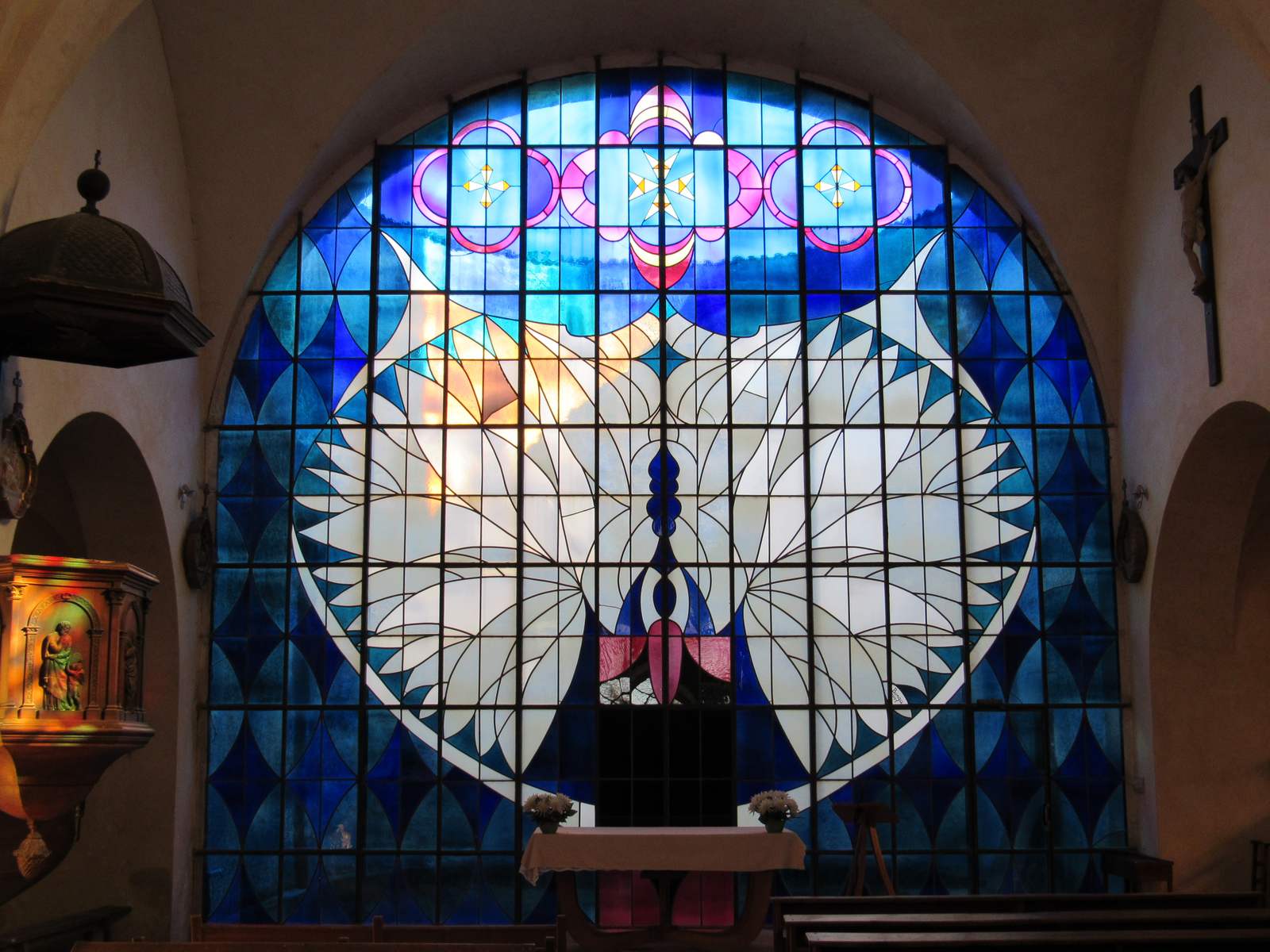 Le vitrail de Franco Borga à Saint-Martin-des-Rosiers, une colombe blanche sur fond bleu
