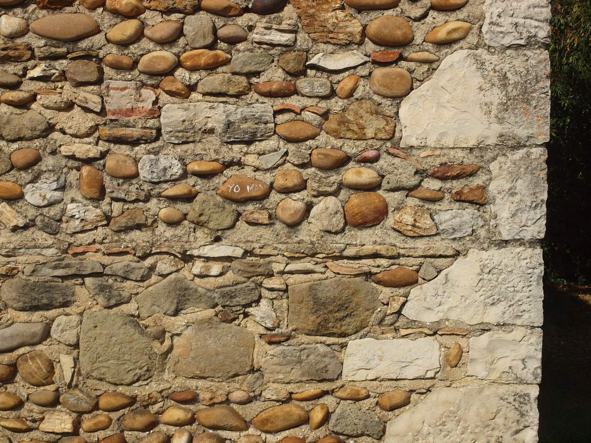 Maçonnerie de galets et de pierres d'un mur à Allan