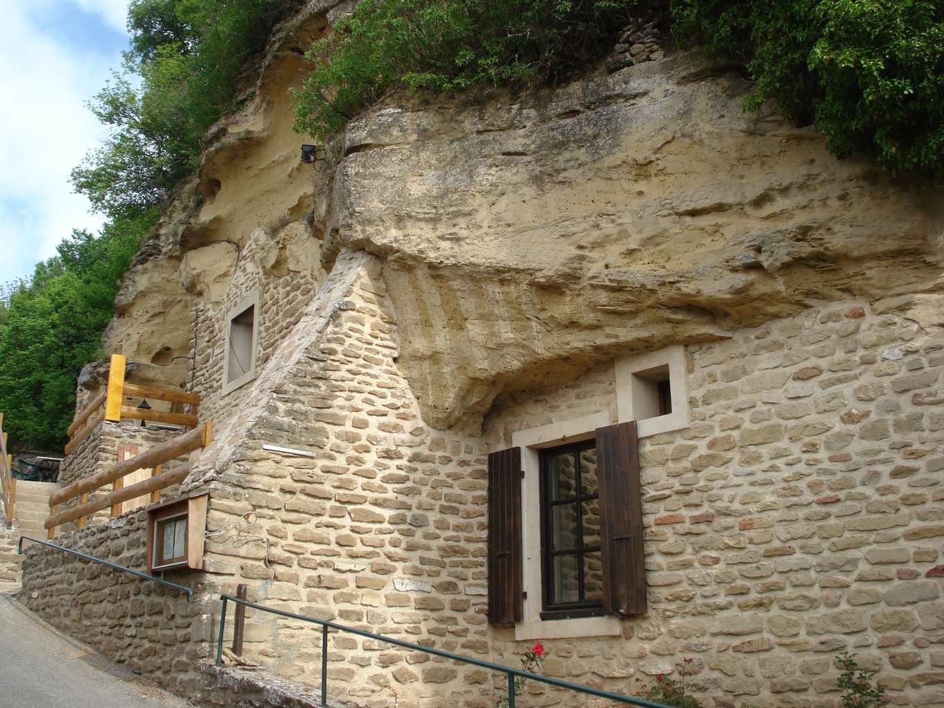 Maison troglodyte de Bathernay adossée sous un auvent de molasse, dont la roche forme la toiture