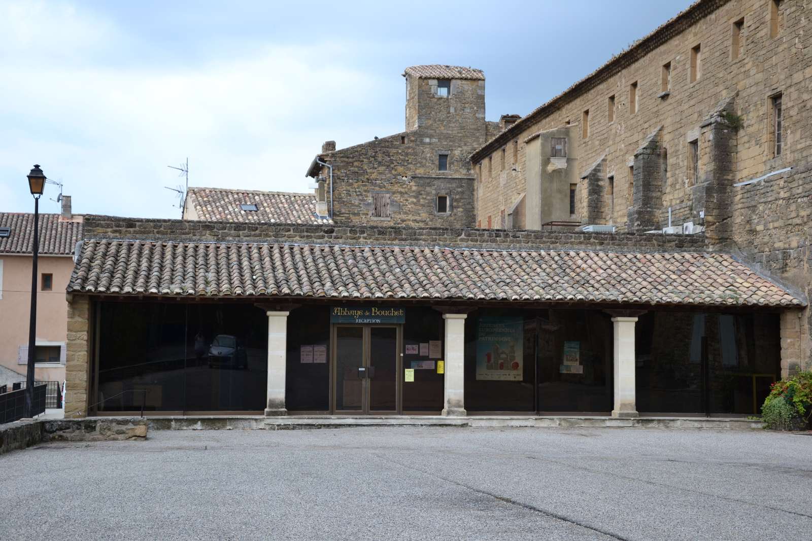 La réception de l'abbaye de Bouchet sous ses arcades, et le bâtiment monastique derrière