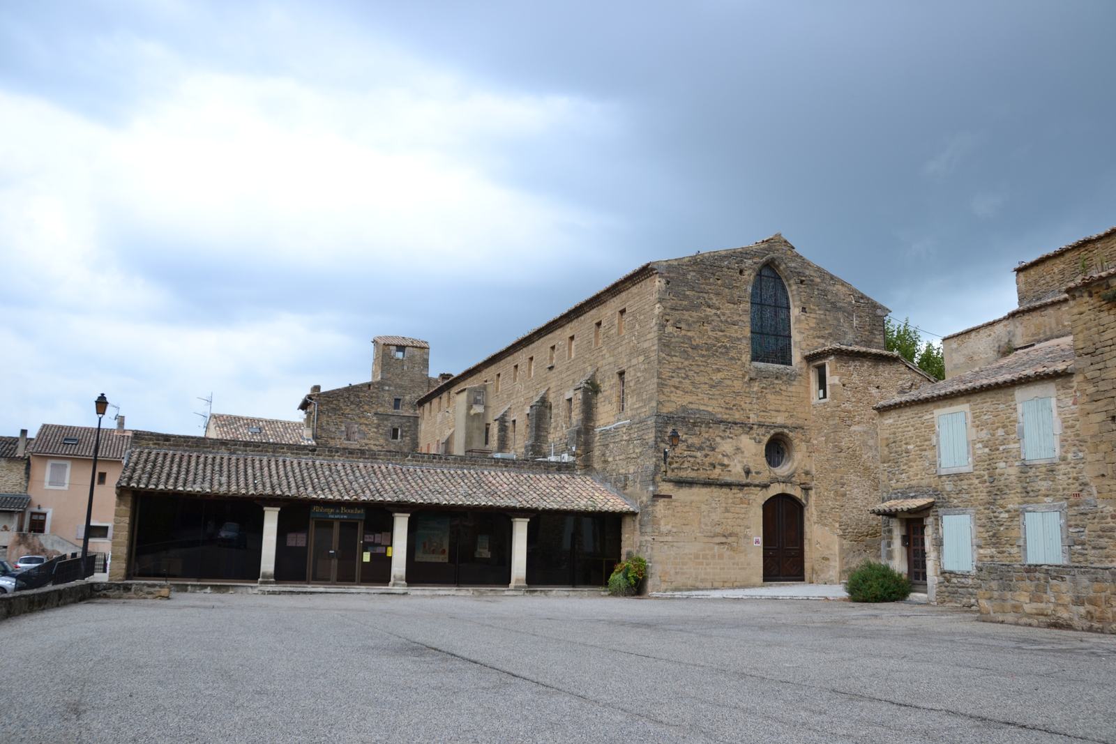 La place de l'Abbaye à Bouchet, avec l'abbatiale et le long bâtiment monastique