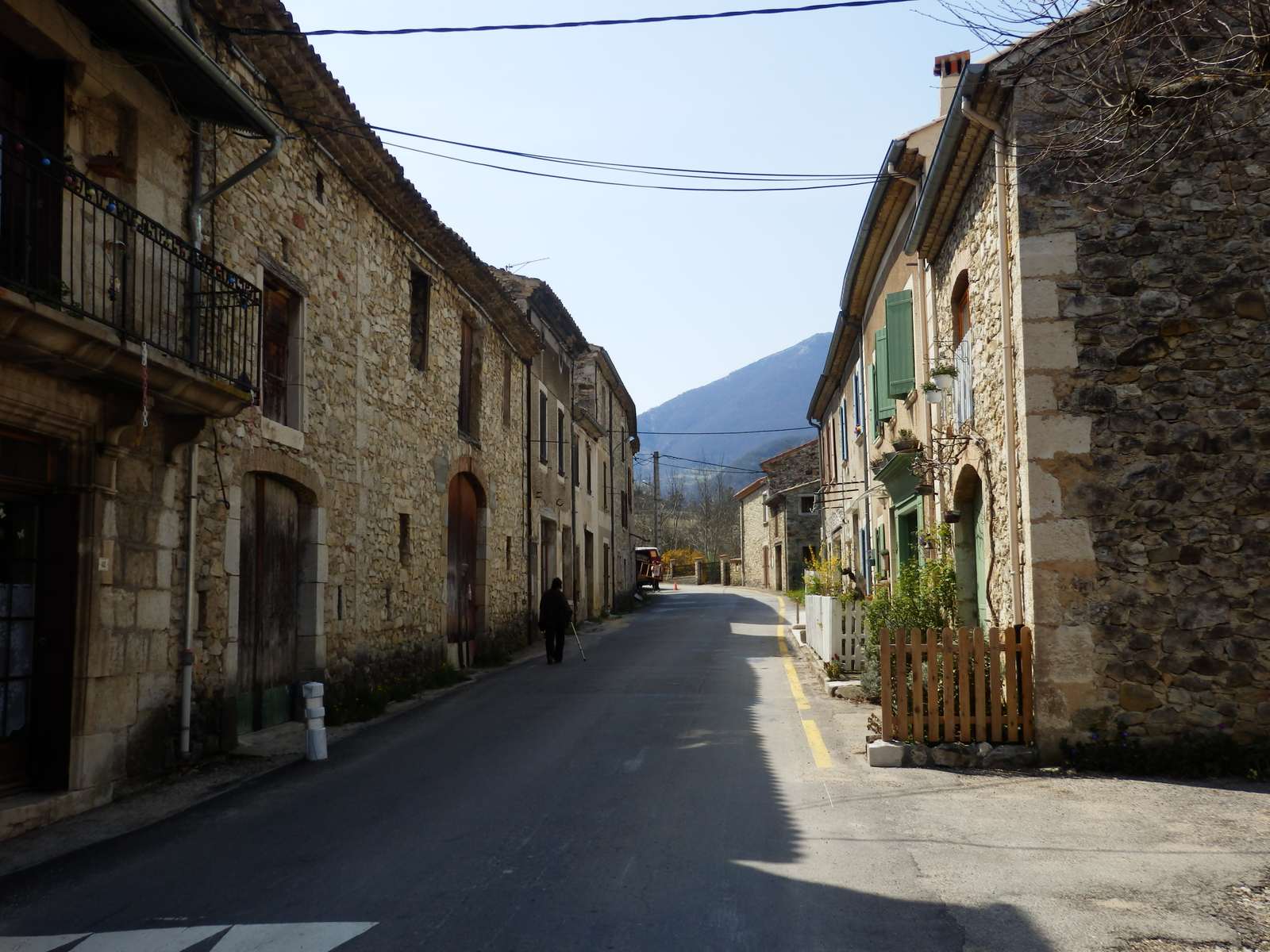 La grand-rue de Bouvières bordée de maisons de pierre, une montagne au fond