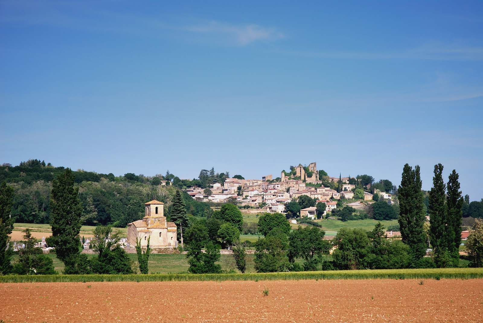 Le village perché de Chabrillan et, à gauche dans la plaine, l'église Saint-Pierre isolée dans son cimetière
