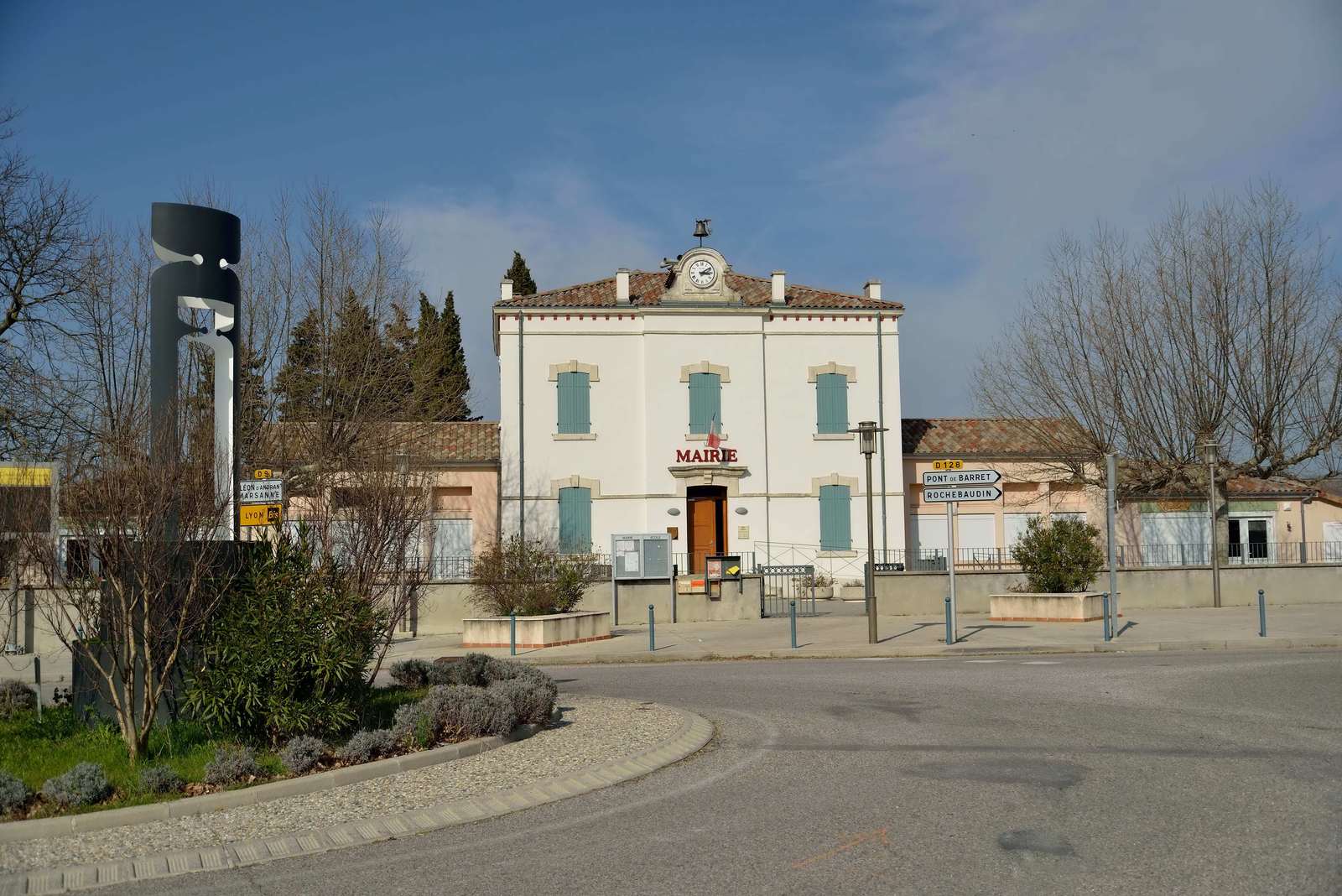 La mairie de Charols, façade claire à fronton et horloge, au bout d'une place