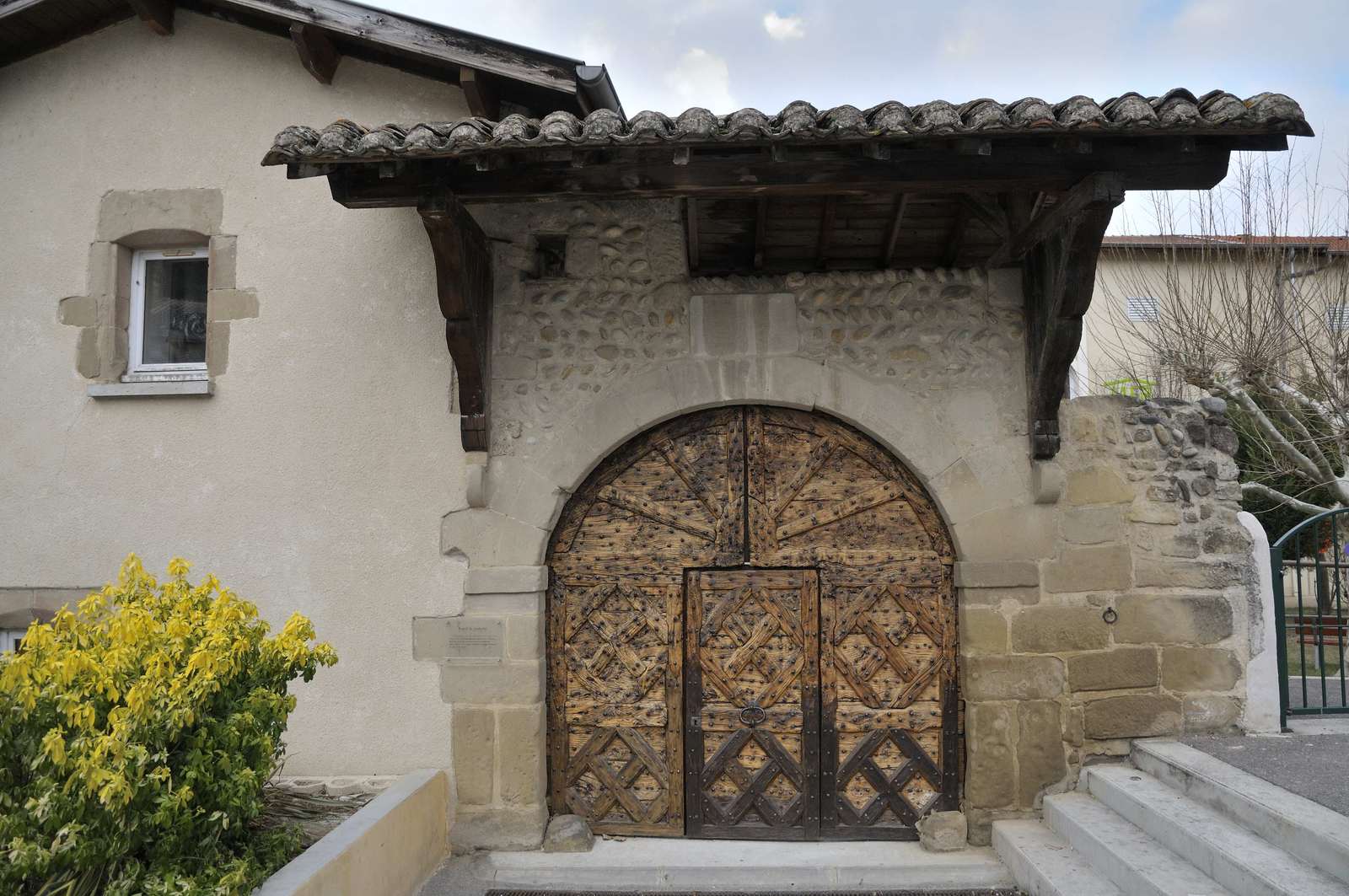Portail du 17e siècle à Châteauneuf-sur-Isère, arc de molasse et vantaux cloutés