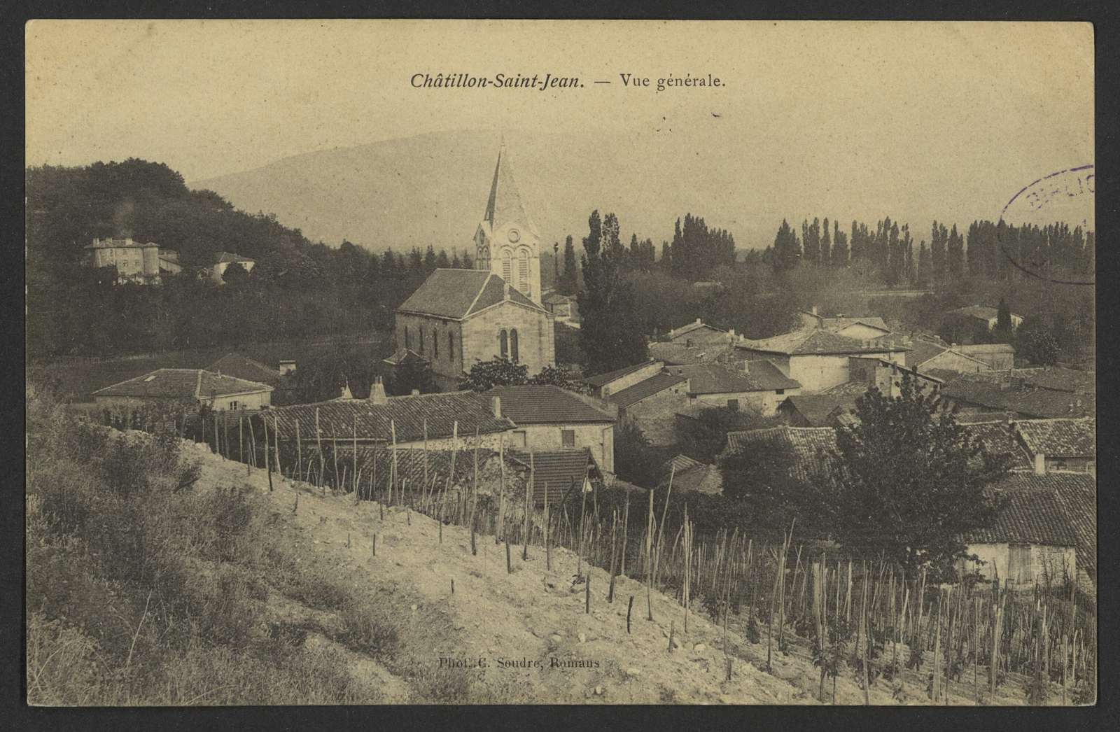 Carte postale ancienne de Châtillon-Saint-Jean, le village et son église à clocher pointu vus depuis une vigne, avec le château à gauche sur la colline boisée