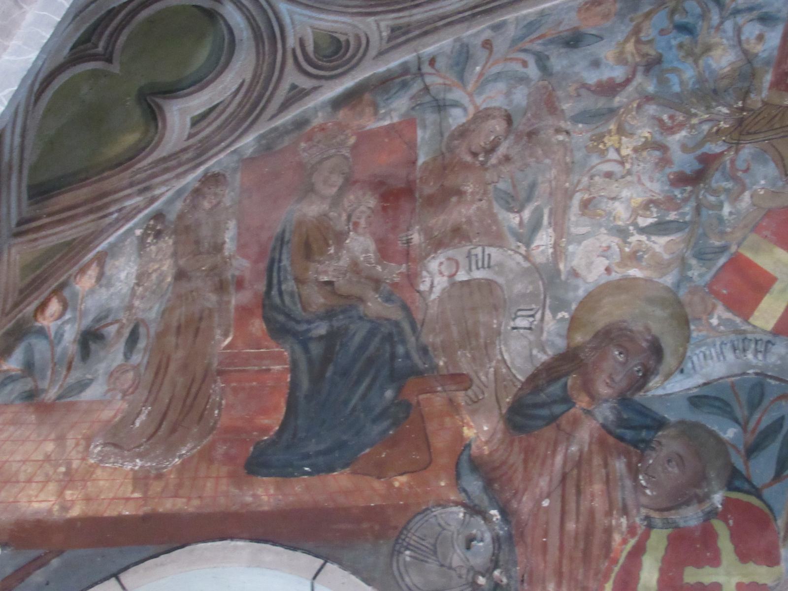 Peinture murale colorée sous une voûte, une Vierge à l'Enfant entourée de personnages en prière et d'un écusson rouge à croix blanche