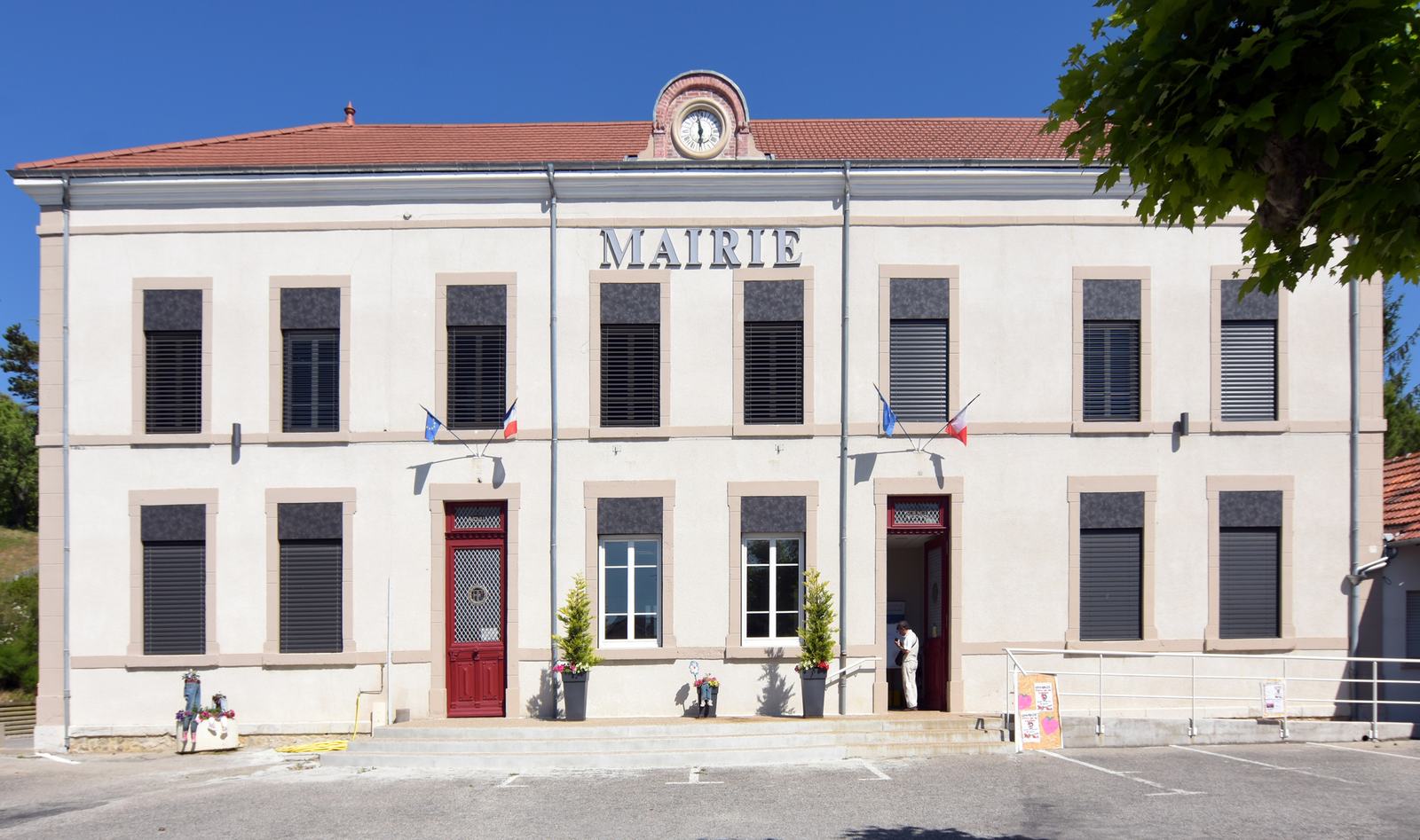 La mairie d'Épinouze, bâtiment à deux étages, façade blanche, horloge au fronton et inscription Mairie