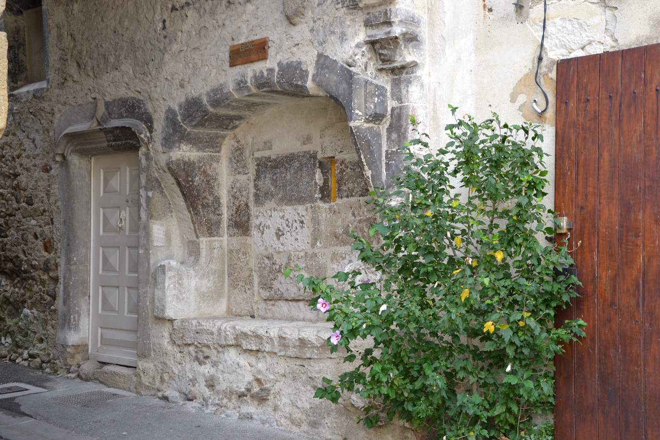 Le banc de justice d'Espeluche, banc de pierre sous une arcade dans la façade d'une maison