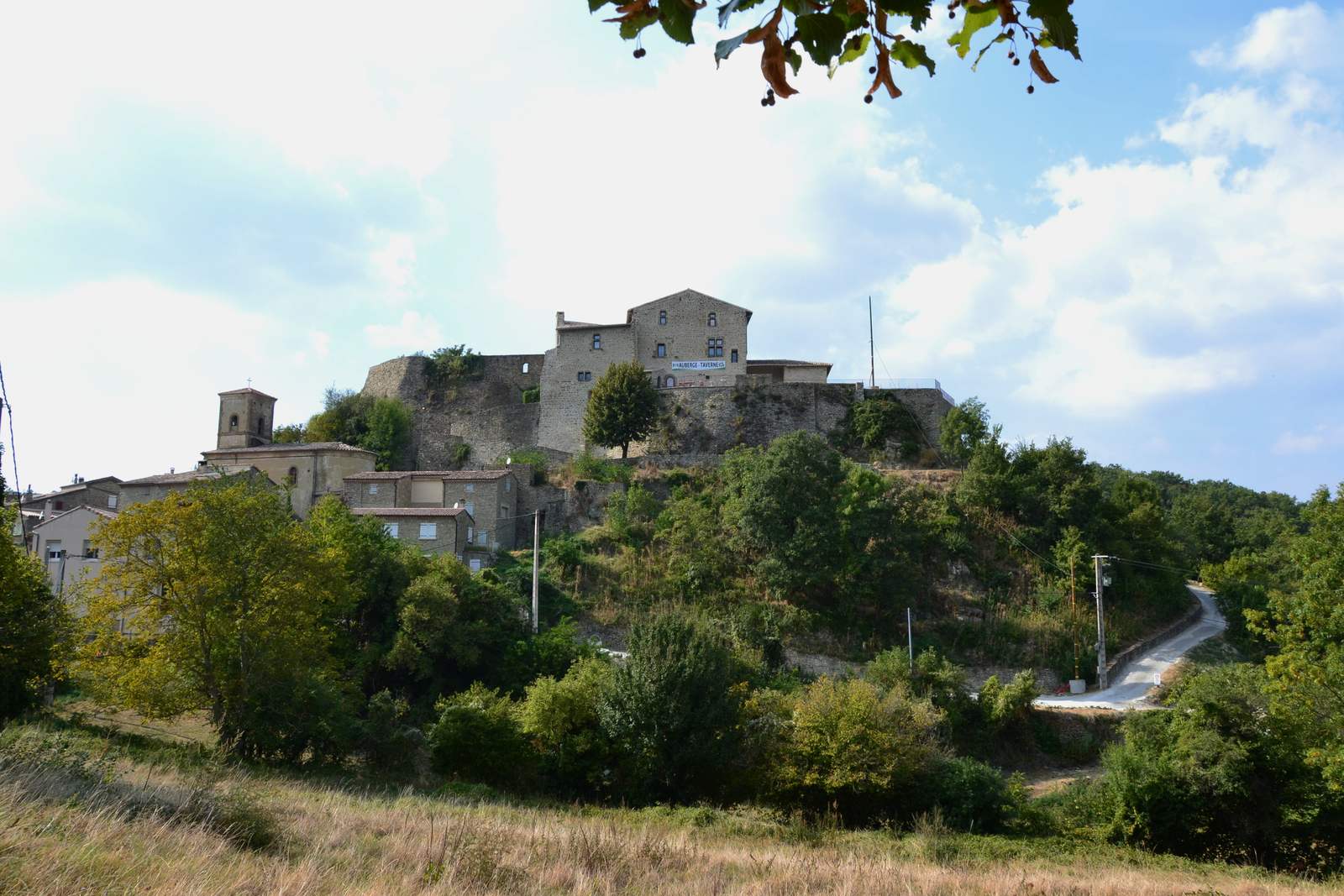 Le village du Poët-Célard sur son rocher, avec le château et le clocher de l'église