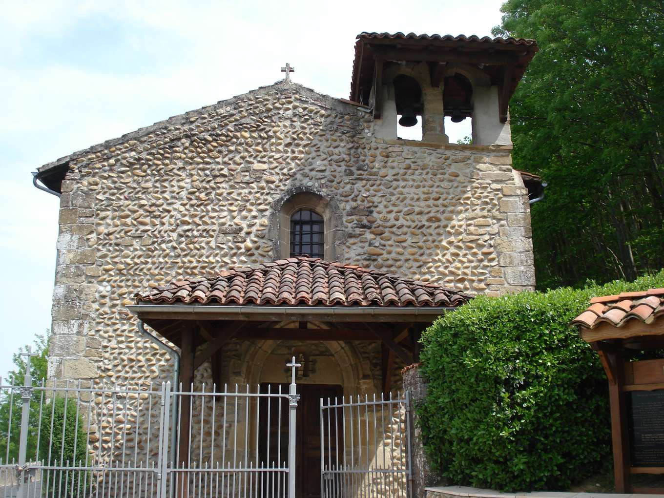La chapelle Notre-Dame de Châtenay, façade en galets, clocher-mur à deux cloches et porche couvert de tuiles