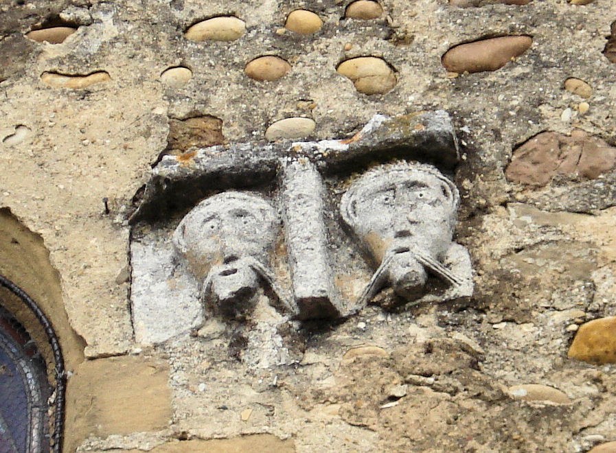 Têtes sculptées sur la façade de l'église du prieuré de Manthes