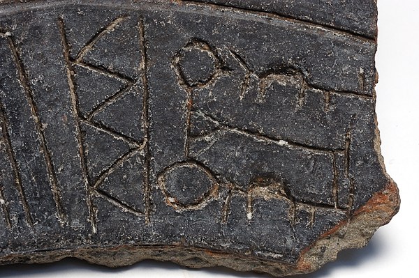 Fragment de poterie noire gravé de signes, lignes, chevrons et boucles