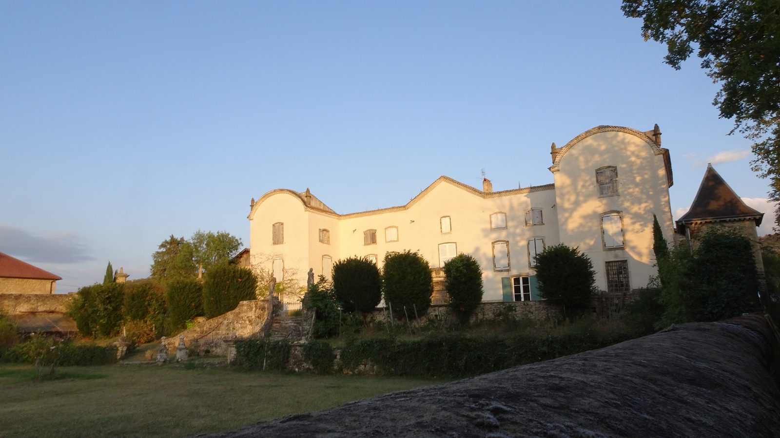 Le château de Sallmard à Peyrins, longue façade claire et tour à toit pointu, dans la lumière du soir