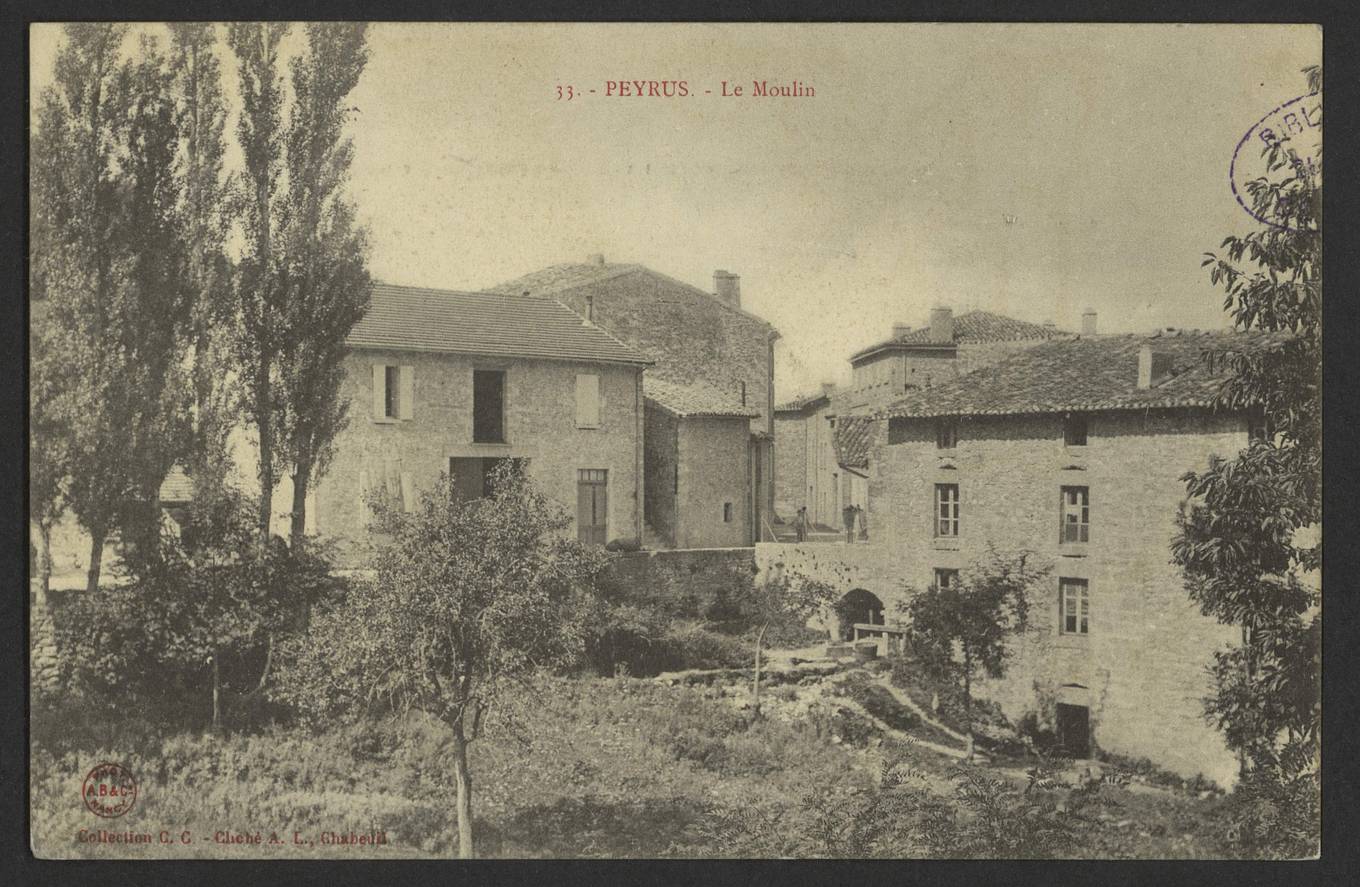 Carte postale ancienne en noir et blanc, le moulin de Peyrus, plusieurs bâtiments de pierre à étages au bord d'un ruisseau, derrière des arbres