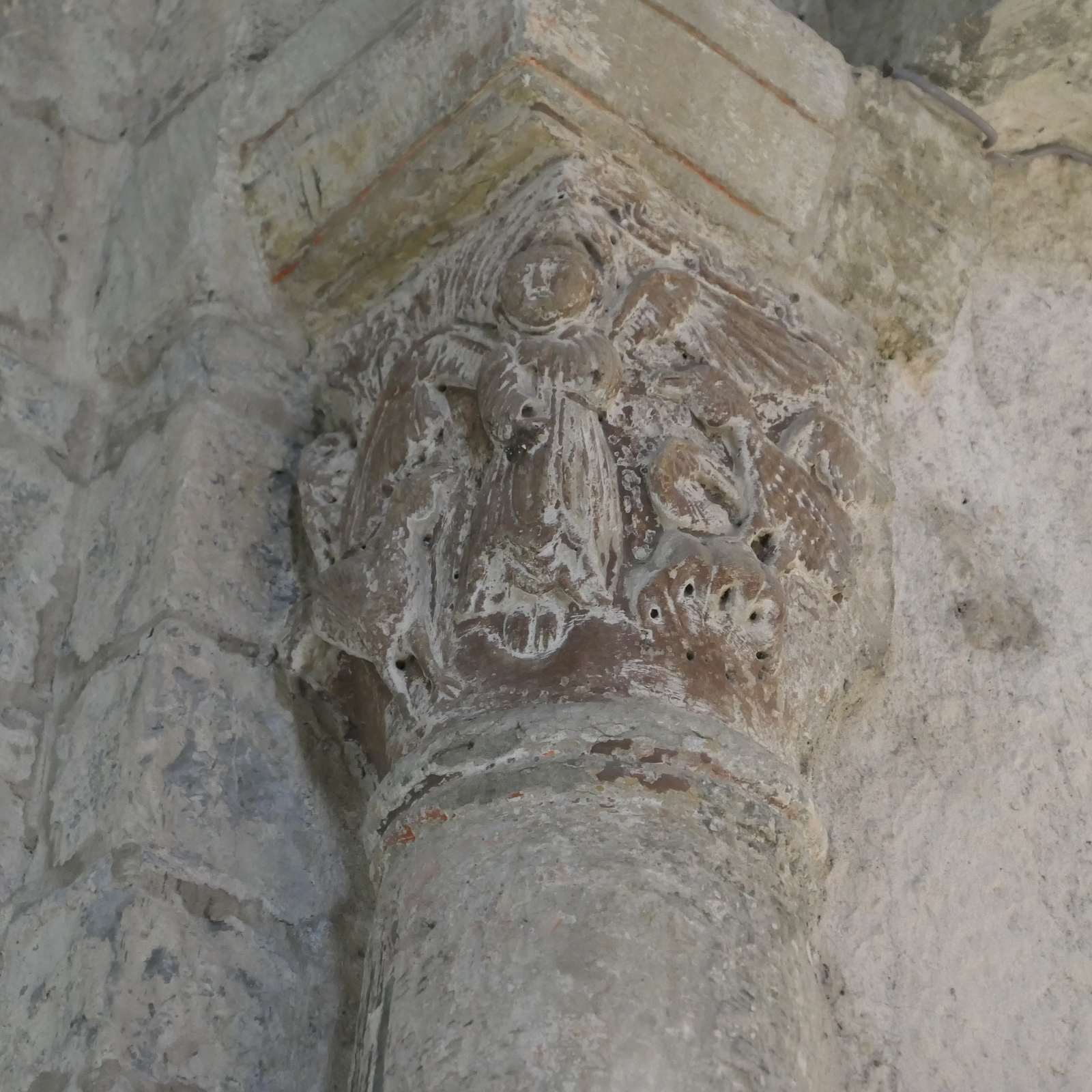 Un chapiteau roman de l'église de La Clastre, sculpté d'un ange aux ailes déployées au-dessus d'une colonne ronde
