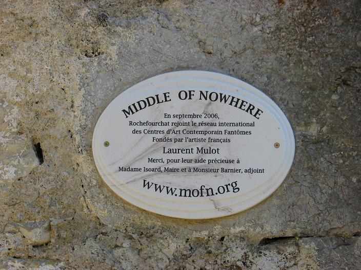 La plaque Middle of Nowhere posée sur le mur de l'église de Rochefourchat