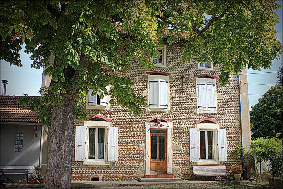 Maison de Saint-Sorlin-en-Valloire dont la façade entière est parée de galets posés en arêtes de poisson, avec arcs de brique