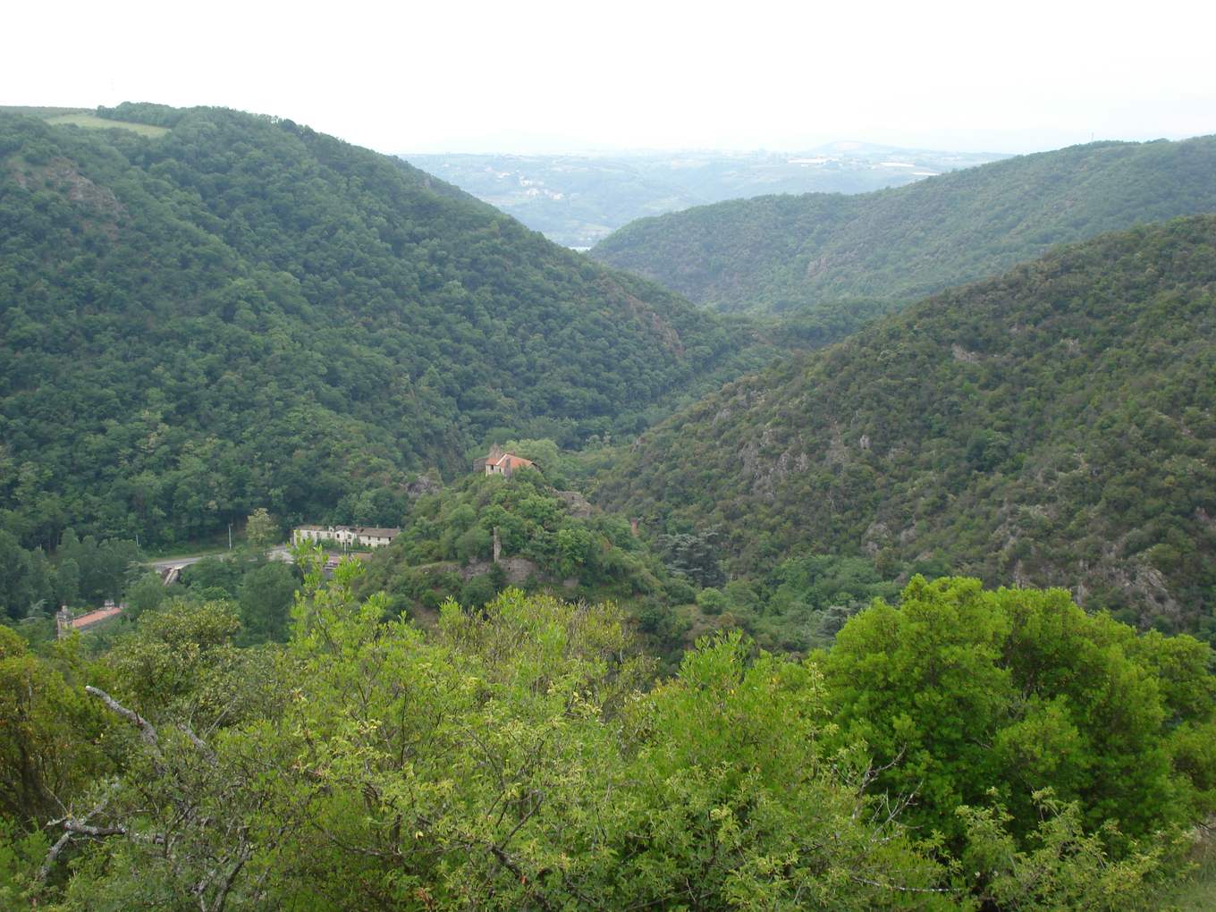 La vallée de la Galaure vue des hauteurs de Saint-Uze, gorges boisées et chapelle sur un éperon