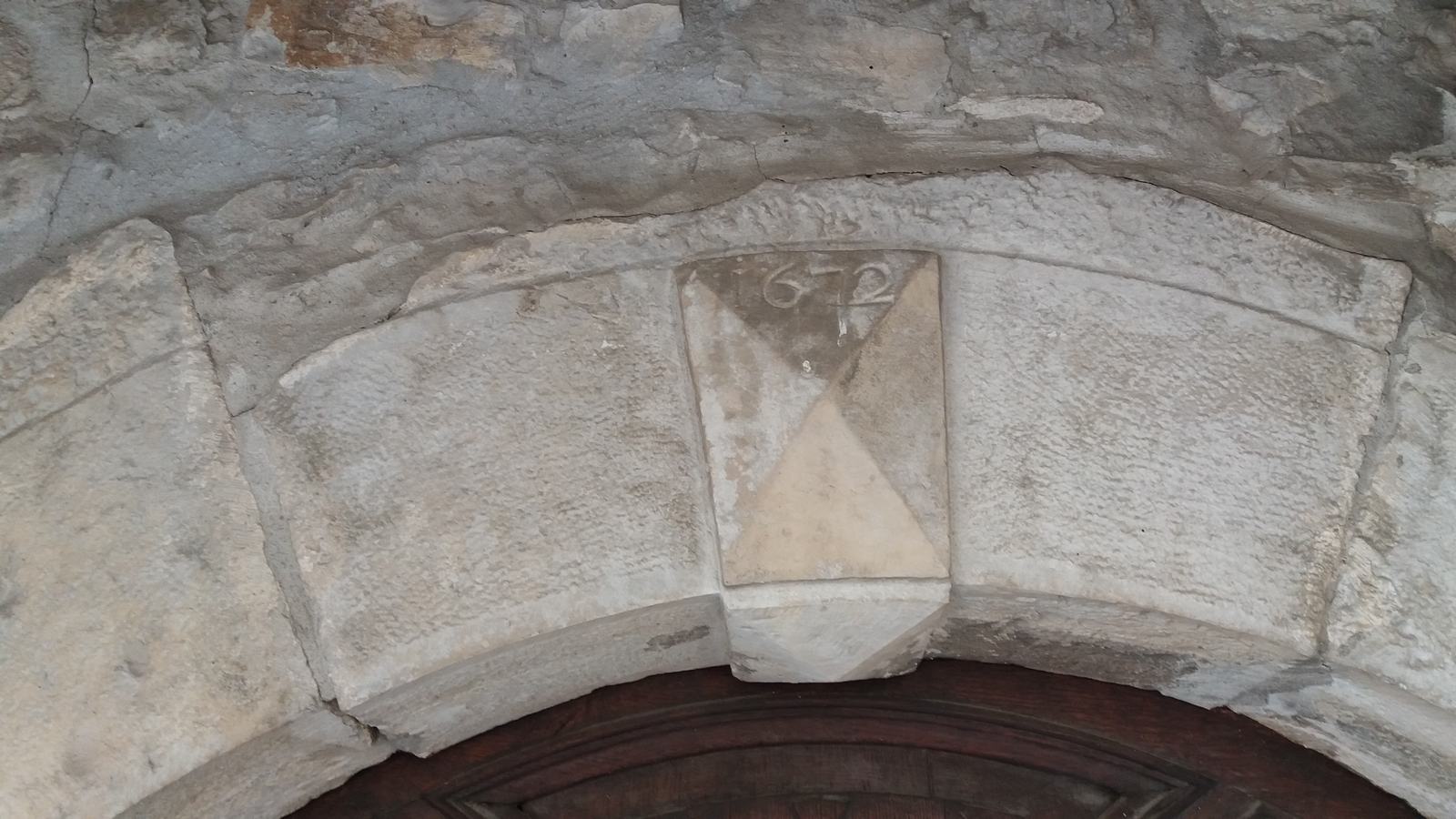 La date 1672 gravée au-dessus d'une porte de l'église Saint-Lambert de Sauzet