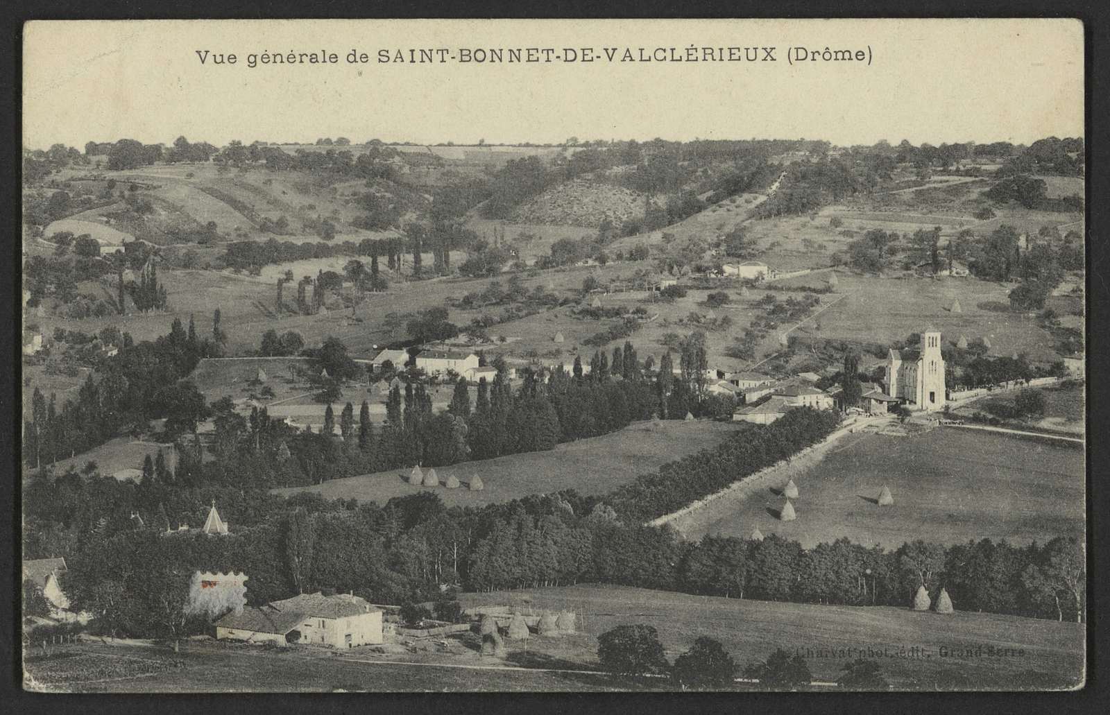 Vue générale de Saint-Bonnet-de-Valclérieux vers 1905, vallon bocager couvert de meules de foin, l'église et sa tour carrée à droite